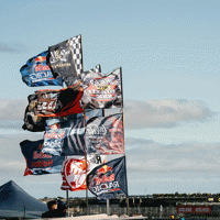 12 racing flags flapping in the wind at The Bend
