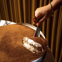 The barman measures out the ingredients for a cocktail behind Fugazzi's signature burgandy marble bar. 