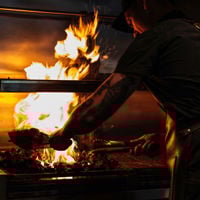 Jake Kellie stands with his hands on the bench in his open kitchen at Arkhe. 