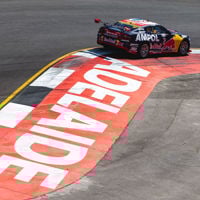 A race car skirts around the track that has the word 'Adelaide' painted on the bitumen 