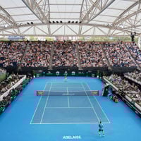 Spectators sit in their seats at The Drive watching world-class tennis players play on the blue court 
