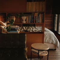 You can see a comfy looking bed through an old wooden bookshelf at The Greenly Carriage