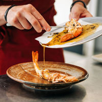 Chef at two-hatted Samphire Restaurant at Rumi on Louth plating prawns 