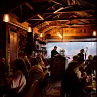 A chef ladling sauce into four small bowls of dumplings at The Little Rickshaw