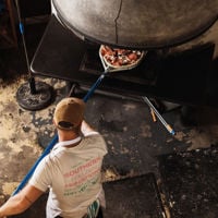 Bird's-eye view of a pizzaiolo putting a pizza in the wood fire oven at Pizzatecca  