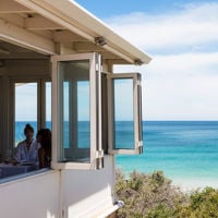 A view past the open windows of Star of Greece to the turquoise water and blue sky 