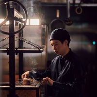 Chef putting skewered meats onto the smoker at Muni 