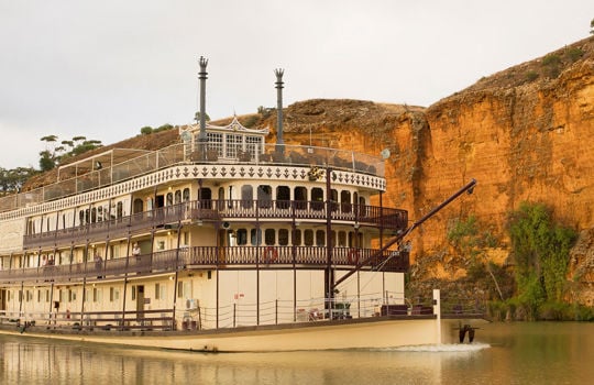 Murray Princess boat sailing along in front of red cliffs